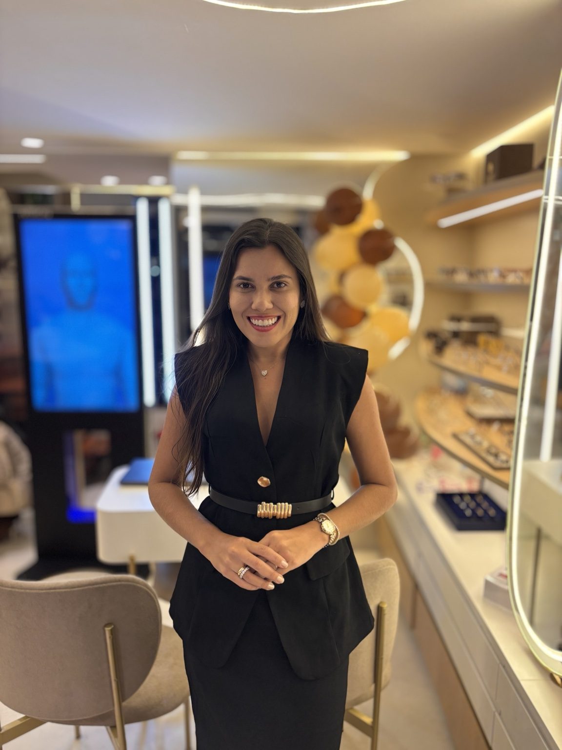 Irla Timbó usando blazer preto no interior da Lumity Ótica, projeto comercial executado pelo escritório